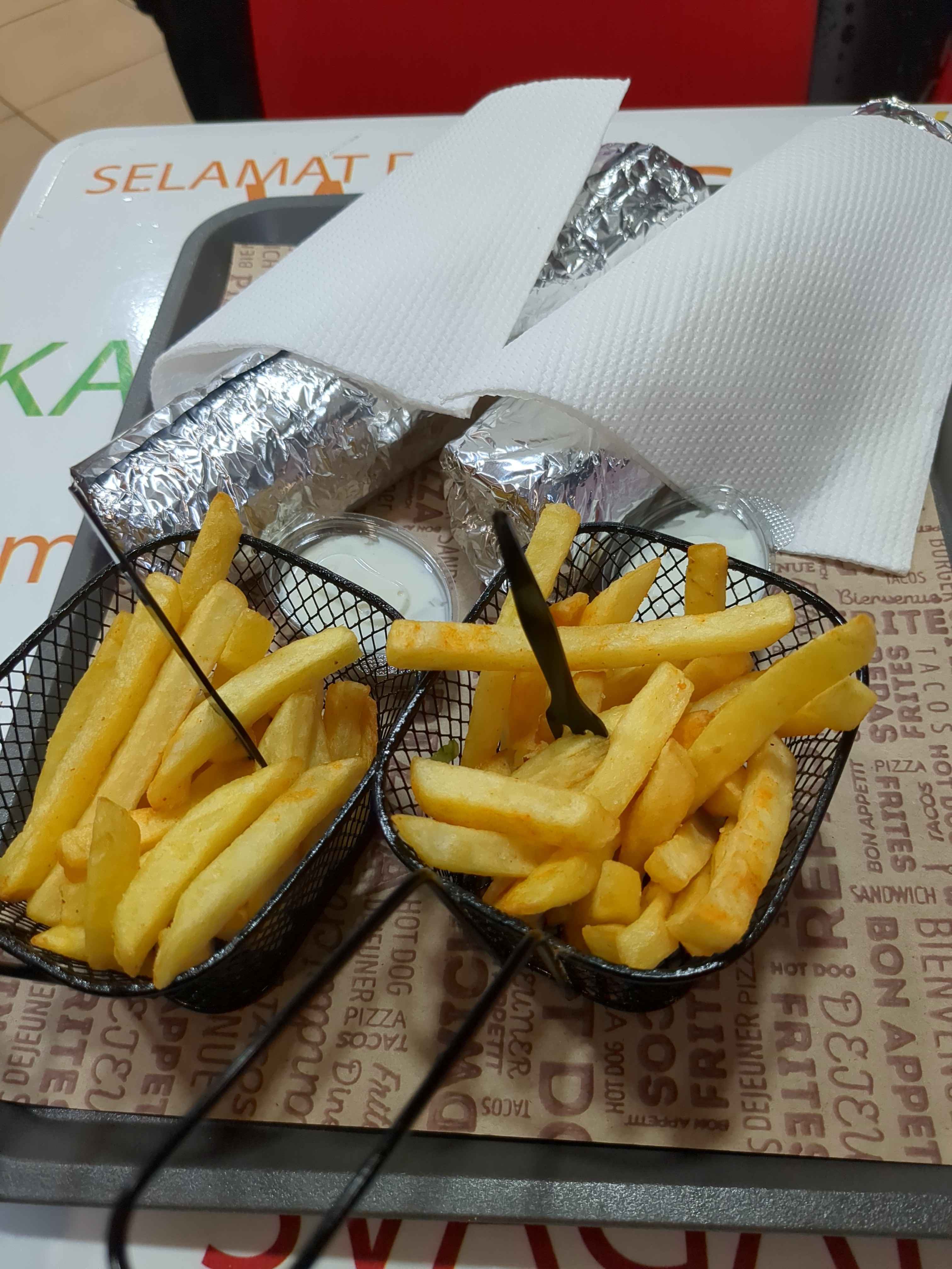 two durums wrapped in aluminum with fries and sauce